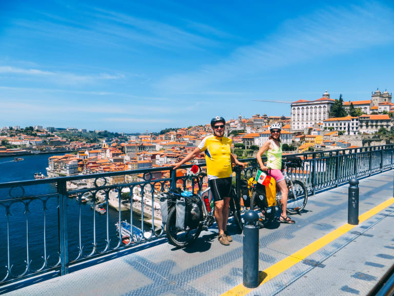 Ciclisti fermi sul ponte Dom Luís I con vista sul centro storico di Porto